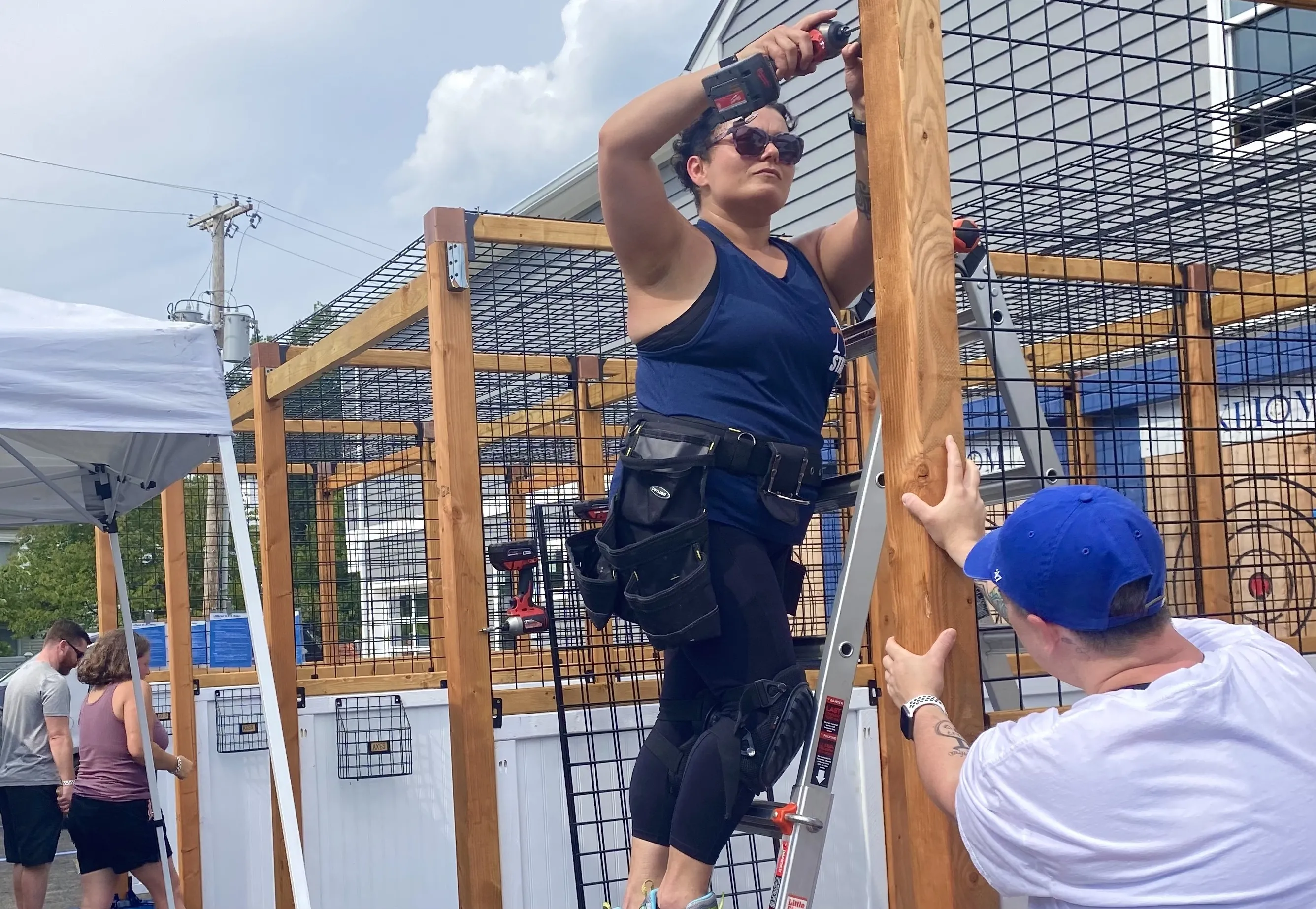 Carly on ladder, holding screwdriver