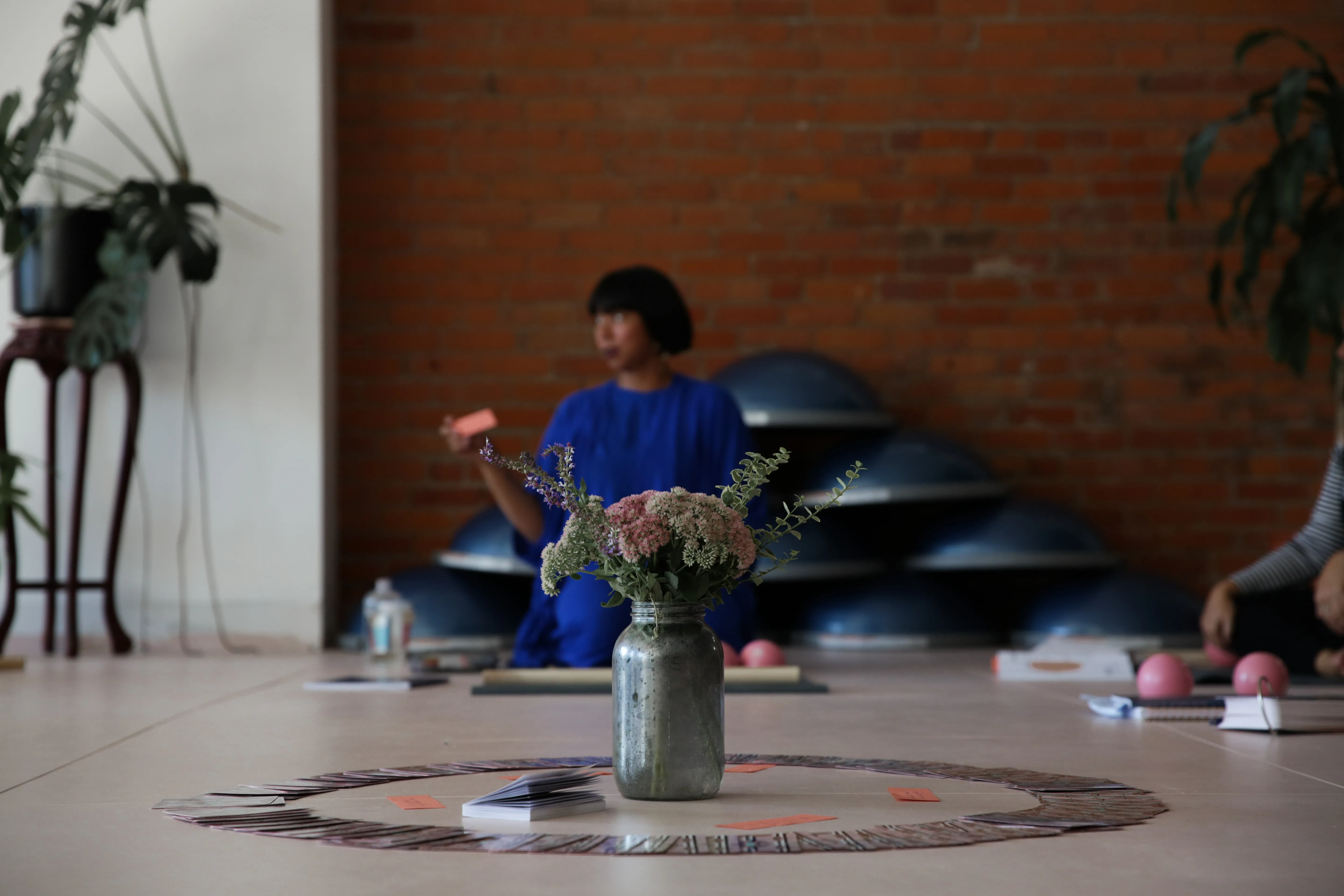 A photo at the GOODBODYFEEL studio with a bouquet of flowers in the middle of a circle of people.